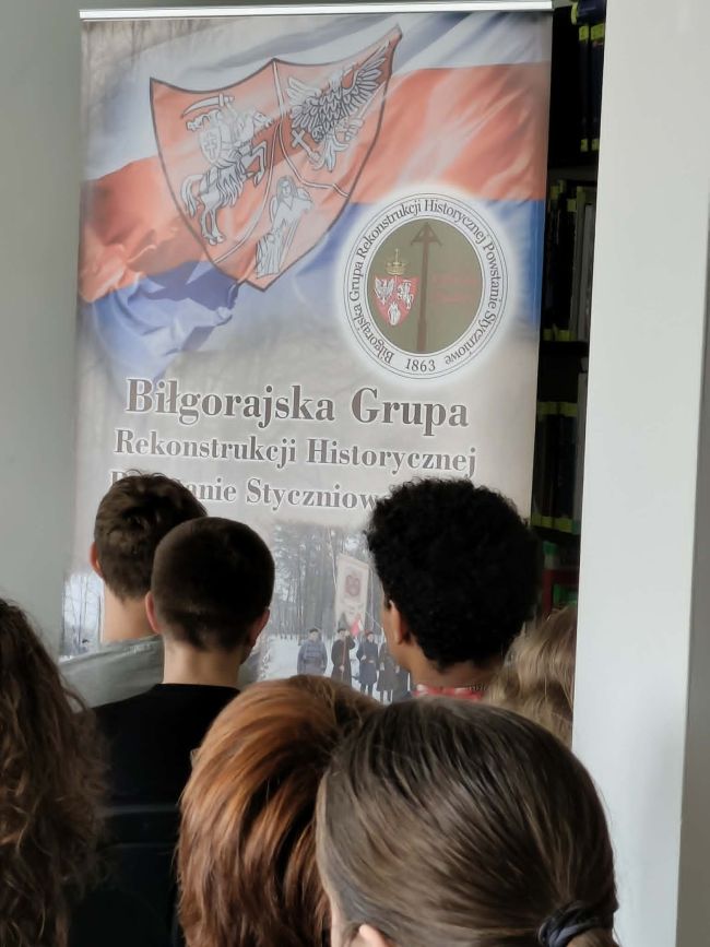 mężczyzna w stroju powstańca pokazuje flagę