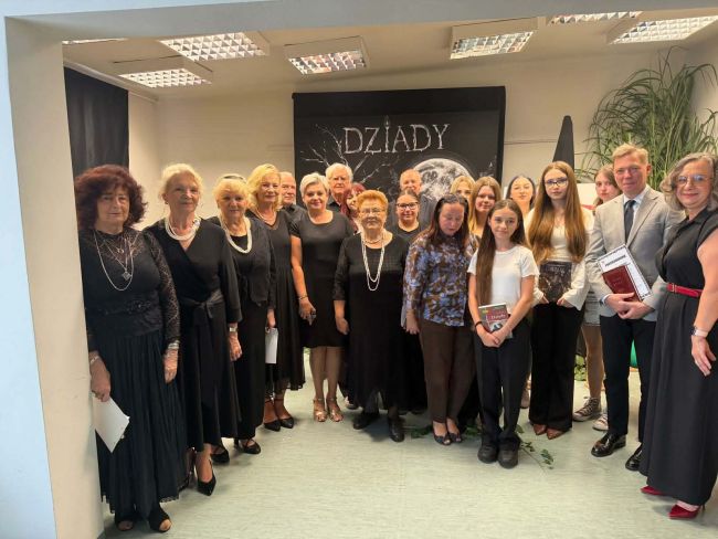 ludzie stojący pod napisem Dziady