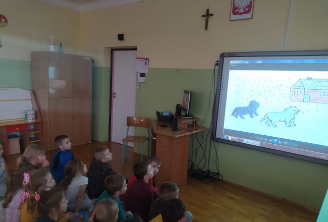Na zdjęciu dzieci oglądają bajkę