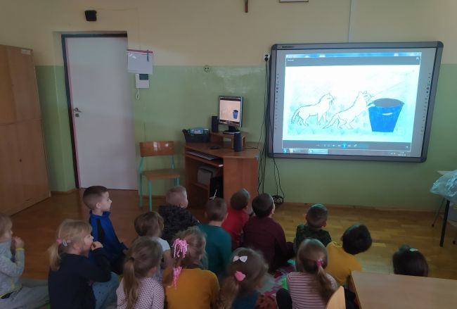 Na zdjęciu dzieci oglądają bajkę