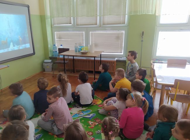 Na zdjęciu dzieci słuchają utworu o zimie