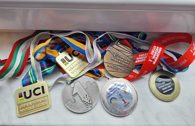 na zdjęciu medale gościa spotkania zdobyte w maratonach 