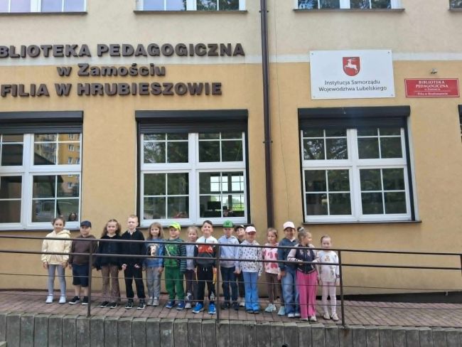 Przedszkolaki przed budynkiem biblioteki