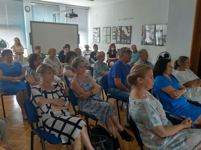 Autor wręcza kierownikowi biblioteki pamiątkową rycinę z książki.