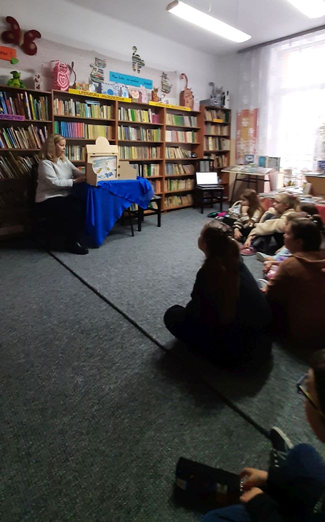 Klasa szkolna. Na zdjęciu uczniowie z nauczycielem oraz prowadząca zajęcia.
