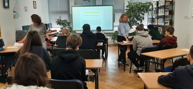 Uczniowie siedzą w ławkach. Nauczyciele bibliotekarze prowadzą zajęcia o Melchiorze Wańkowiczu – patronie roku 2024