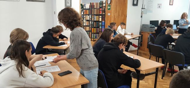 Uczniowie siedzą w ławkach. Nauczyciele bibliotekarze prowadzą zajęcia o Melchiorze Wańkowiczu – patronie roku 2024