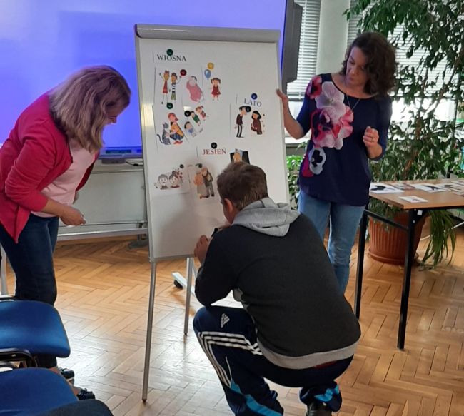 Uczeń przyczepia obrazki na flipchardzie.