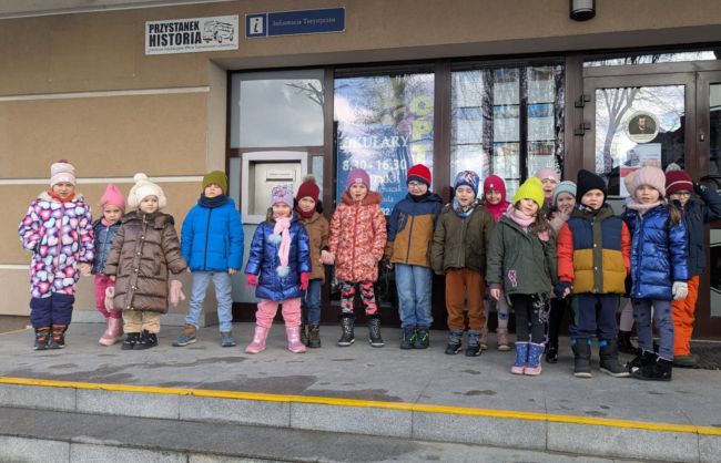 Przedszkolaki przed budynkiem biblioteki