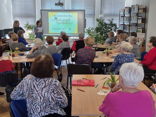 Wszystkie uczestniczki spotkania siedzą przy stolikach.