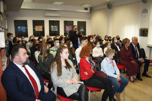 Na zdjęciu widać całą widownię oraz dziennikarza wykonującego zdjęcia zgromadzonych w czytelni Biblioteki Pedagogicznej na podsumowaniu projektu 