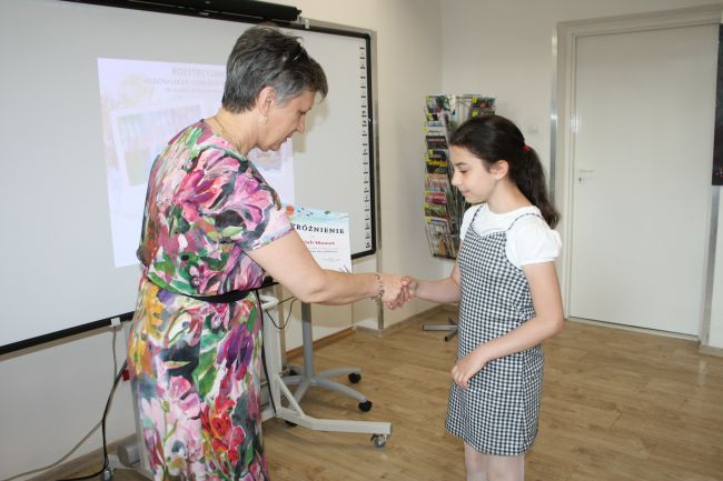 Laureatka konkursu Gabriela Momot odbiera wyróżnienie z rąk dyrektora Biblioteki Pedagogicznej w Zamościu.