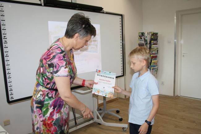 Laureatka konkursu Gabriela Momot odbiera wyróżnienie z rąk dyrektora Biblioteki Pedagogicznej w Zamościu.