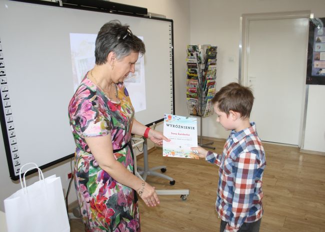 Laureat konkursu Jan Świderek odbiera wyróżnienie z rąk dyrektora Biblioteki Pedagogicznej w Zamościu.