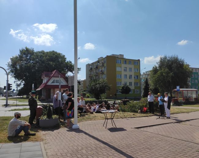 Kobieta przy mówiąca do mikrofonu obok słuchacze