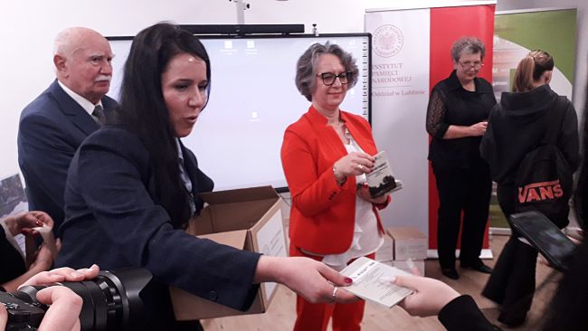 Dyrektor Biblioteki Pedagogicznej w Zamościu oraz pracownica lubelskiego odziału IPN rozdają folder edukacyjny folder edukacyjny