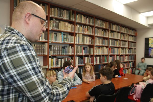 Nauczyciel czyta pytanie dla uczestników rozgrywki Milionerzy w Bibliotece Pedagogicznej.