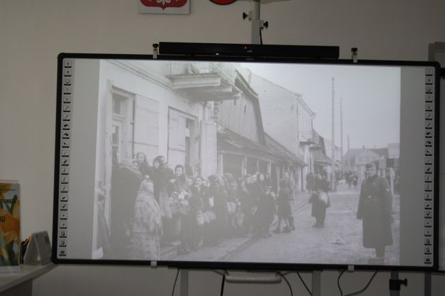 Zdjęcie na tablicy multimedialnej pokazujące społeczność żydowską podczas okupacji hitlerowskiej w Zamościu.
