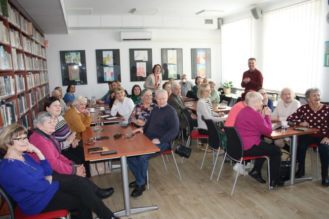 Uczestniczka zajęć wykonuje zadanie na tablicy multimedialnej. Kolejna osoba czeka w kolejce